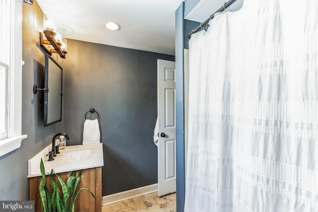 full bathroom with vanity and baseboards