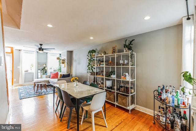 dining room with baseboards, light wood-type flooring, a ceiling fan, and recessed lighting