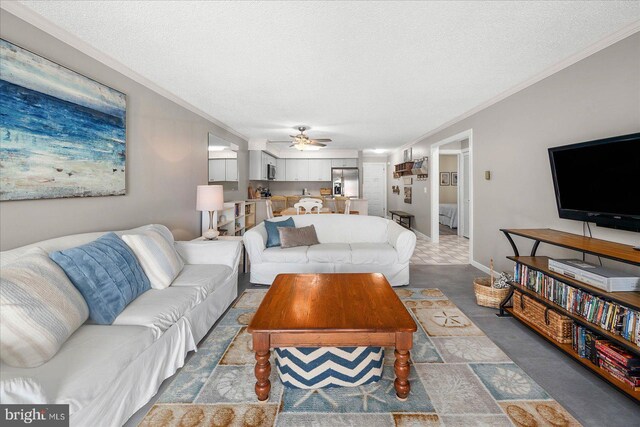 tiled living room with ceiling fan, crown molding, and a textured ceiling