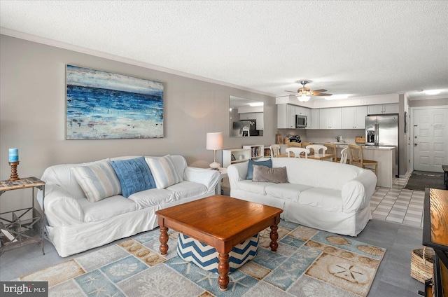 living area featuring ceiling fan, a textured ceiling, and crown molding