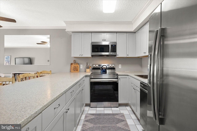 kitchen featuring a peninsula, ceiling fan, a breakfast bar area, and stainless steel appliances