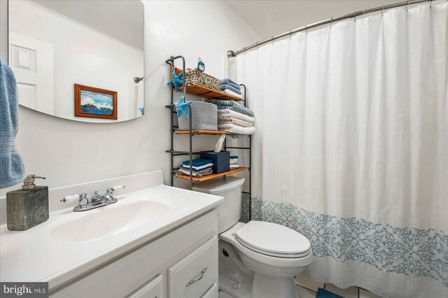 bathroom featuring toilet, walk in shower, and vanity