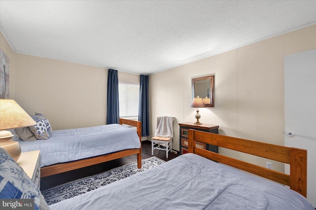 bedroom featuring a textured ceiling and dark wood-type flooring