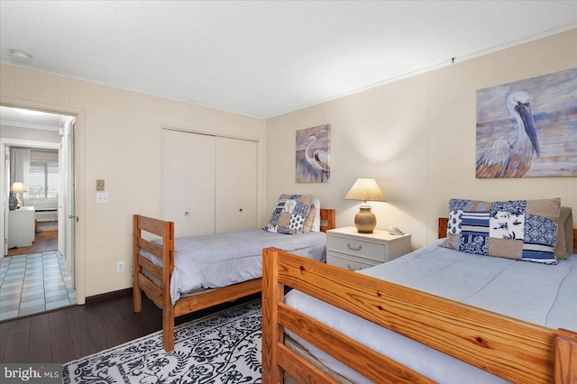 bedroom featuring dark wood-type flooring, a closet, and crown molding