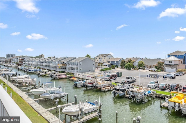 view of dock featuring a water view, boat lift, and a residential view