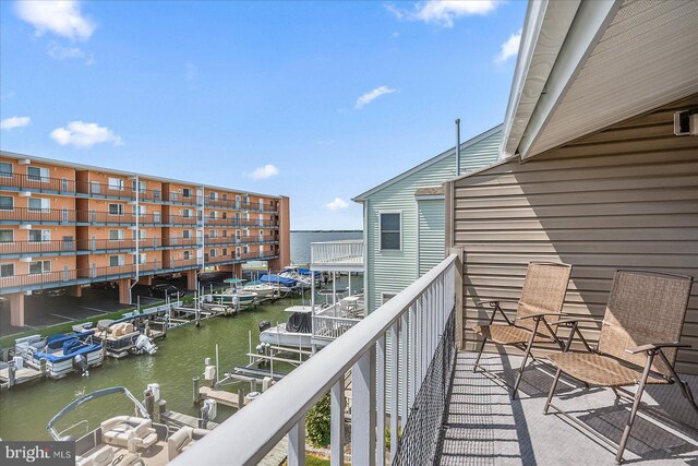 balcony featuring a boat dock and a water view