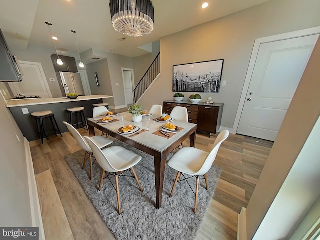 dining space featuring a notable chandelier and light wood-type flooring