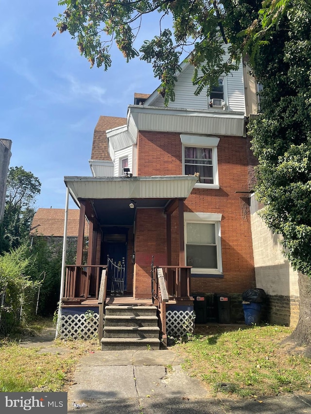 view of front facade featuring covered porch and brick siding