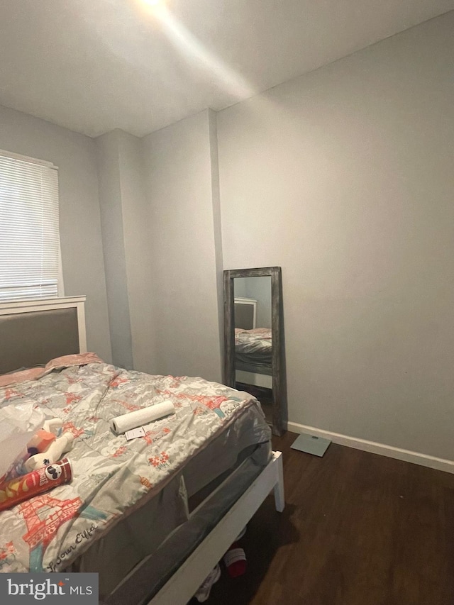 bedroom featuring dark wood-style flooring and baseboards