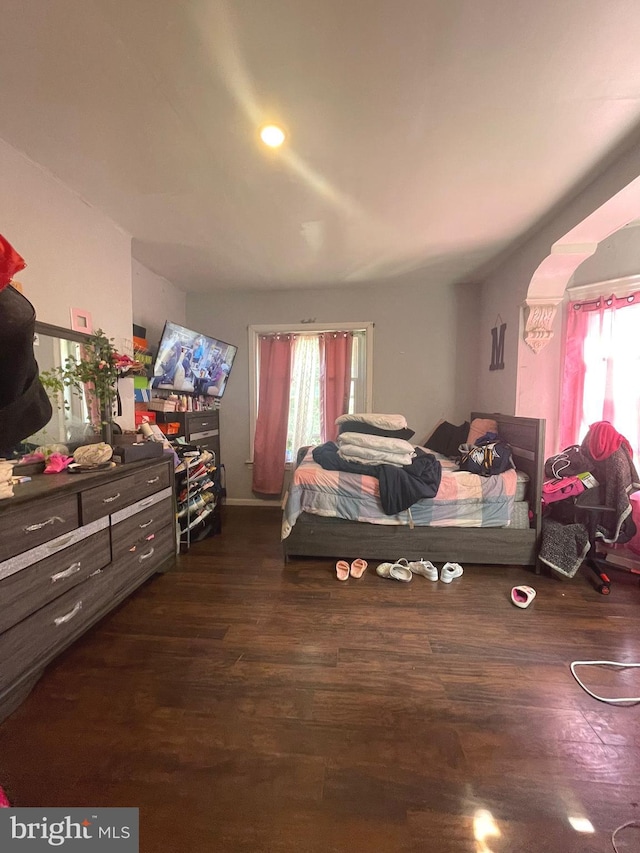 bedroom with multiple windows and dark hardwood / wood-style flooring