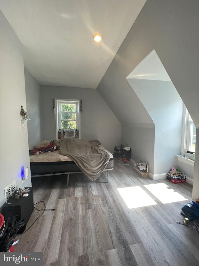 bedroom featuring cooling unit, vaulted ceiling, and hardwood / wood-style floors