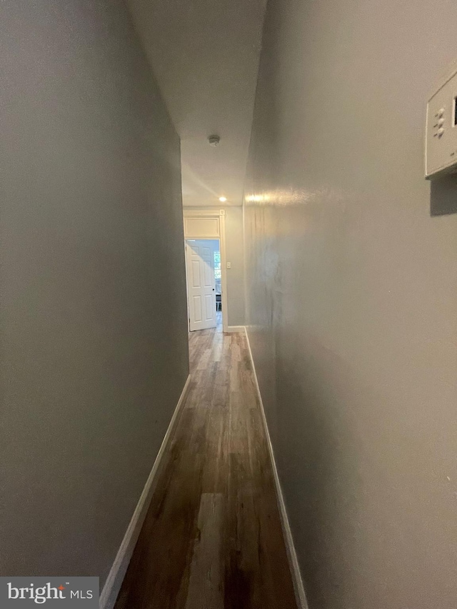 hallway featuring wood finished floors and baseboards