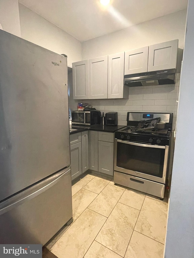 kitchen featuring gray cabinets, stainless steel appliances, tasteful backsplash, and light tile patterned flooring