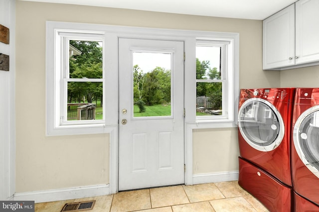 washroom with light tile patterned flooring, cabinet space, visible vents, and washer and dryer