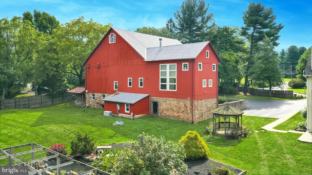 exterior space with fence, an outbuilding, and a yard