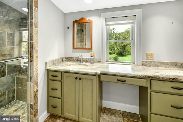 full bath with a stall shower, baseboards, and vanity