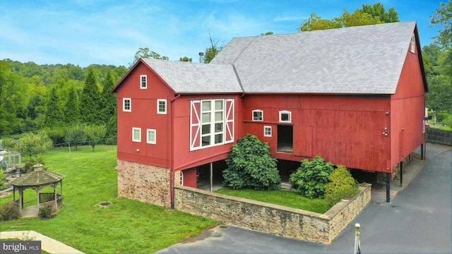 exterior space with a barn, a front lawn, an outdoor structure, and a gazebo