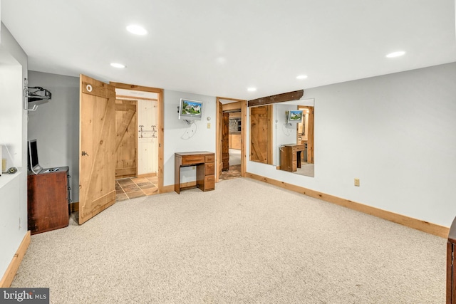 unfurnished bedroom with carpet floors, a barn door, baseboards, and recessed lighting