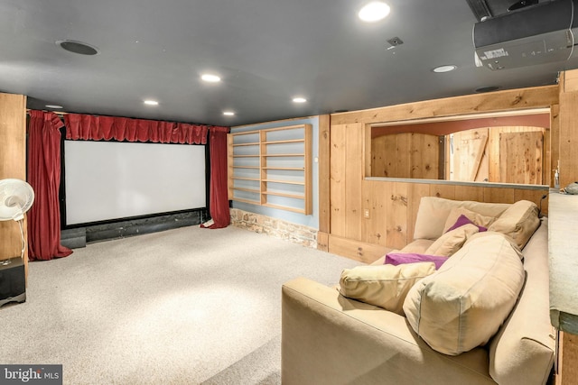 carpeted home theater room with wooden walls and recessed lighting