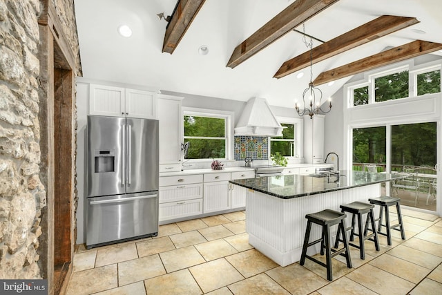 kitchen with appliances with stainless steel finishes, a center island, white cabinetry, and custom exhaust hood