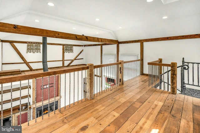 hall with lofted ceiling, light wood finished floors, recessed lighting, and an upstairs landing