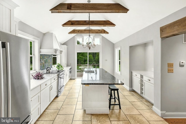 kitchen with an island with sink, premium range hood, white cabinetry, and stainless steel appliances