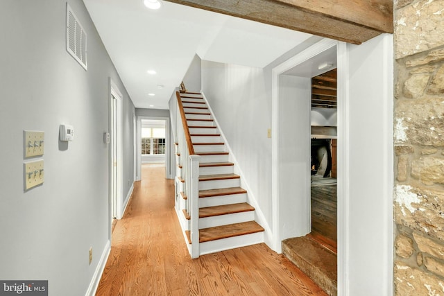 stairway featuring recessed lighting, visible vents, baseboards, and wood finished floors