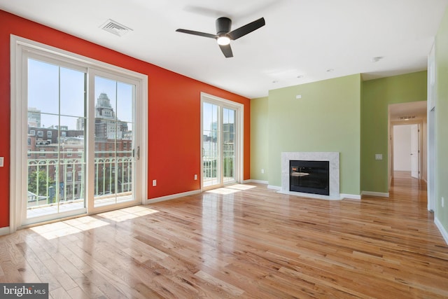 unfurnished living room featuring ceiling fan and light hardwood / wood-style floors