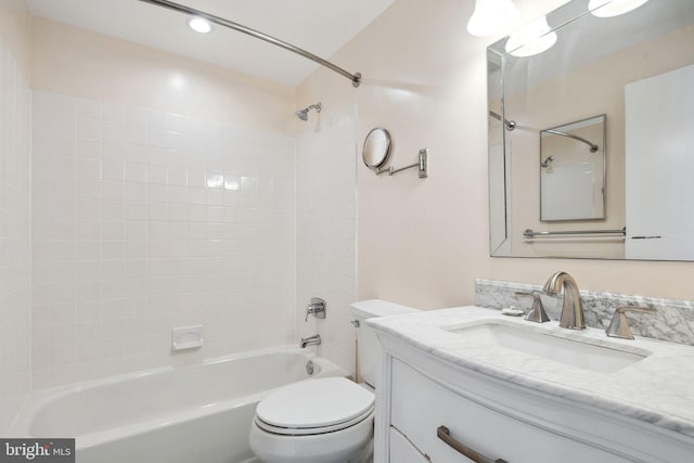 full bathroom featuring toilet, tiled shower / bath, and vanity