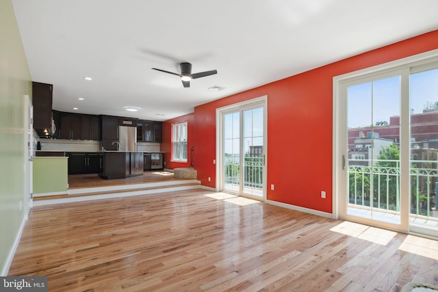 unfurnished living room featuring ceiling fan and light hardwood / wood-style flooring