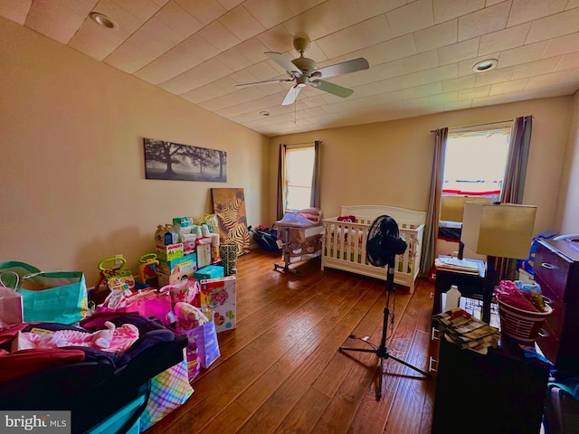 bedroom with ceiling fan, multiple windows, and hardwood / wood-style flooring