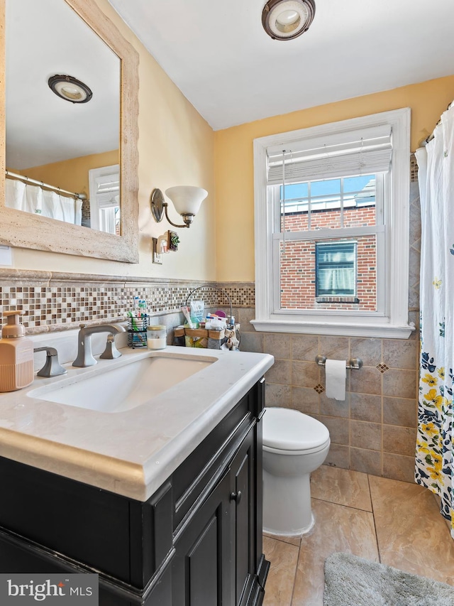 bathroom featuring tile walls, vanity, toilet, and tile patterned floors