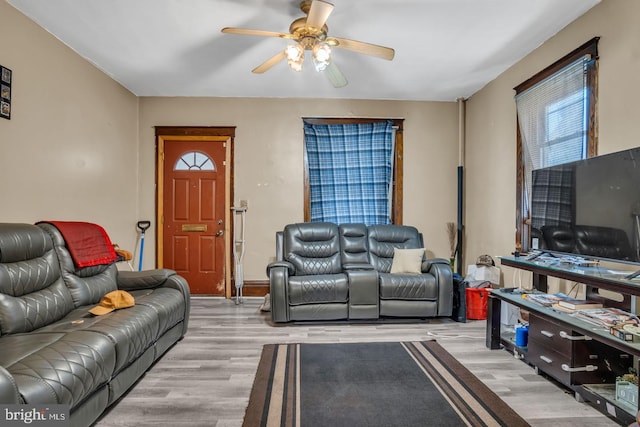 living area featuring light wood-type flooring and a ceiling fan