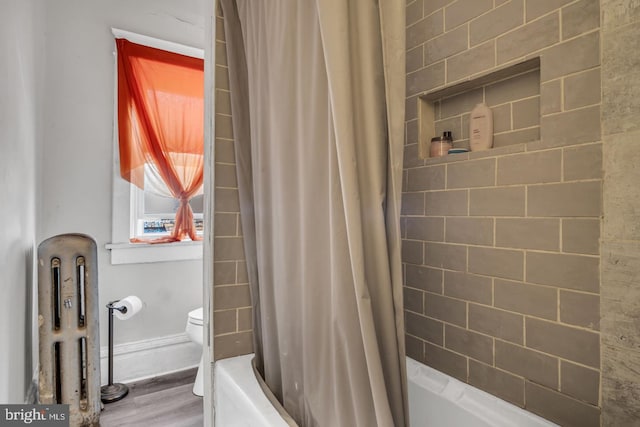 bathroom featuring shower / tub combo with curtain, hardwood / wood-style floors, and toilet