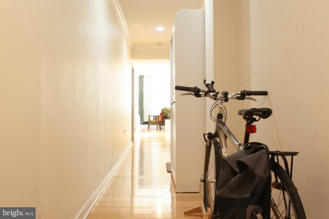 corridor featuring light hardwood / wood-style flooring and crown molding