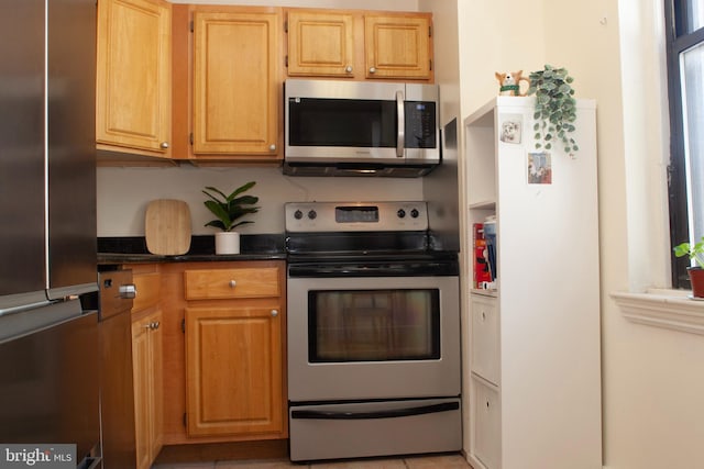 kitchen with stainless steel appliances and dark stone counters