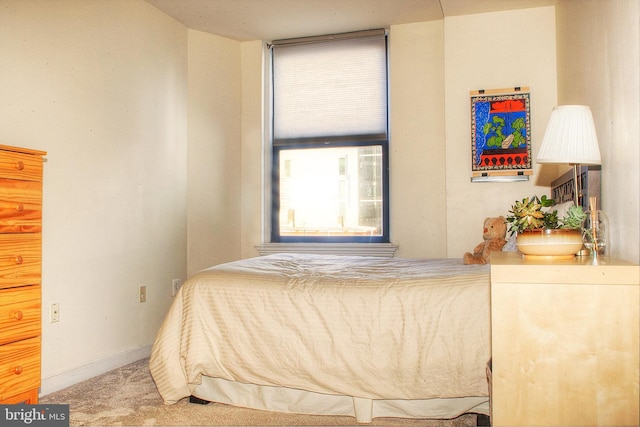 bedroom with light carpet and baseboards