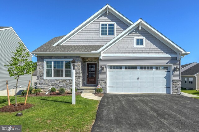 craftsman-style house featuring a garage and a front lawn