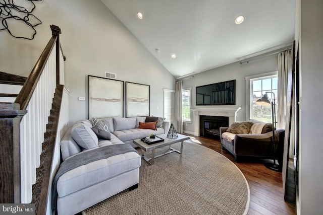 living room with high vaulted ceiling and dark hardwood / wood-style flooring