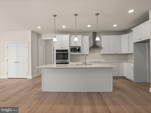 473 Orange Tree Ln, Westminster, MD 21157 - kitchen with wall chimney exhaust hood, appliances with stainless steel finishes, a sink, light countertops, and light wood-type flooring