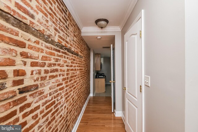 hall featuring hardwood / wood-style floors and brick wall