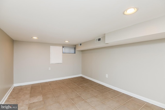 finished below grade area with light tile patterned floors, recessed lighting, visible vents, and baseboards