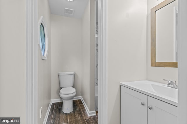 bathroom featuring wood-type flooring, vanity, and toilet