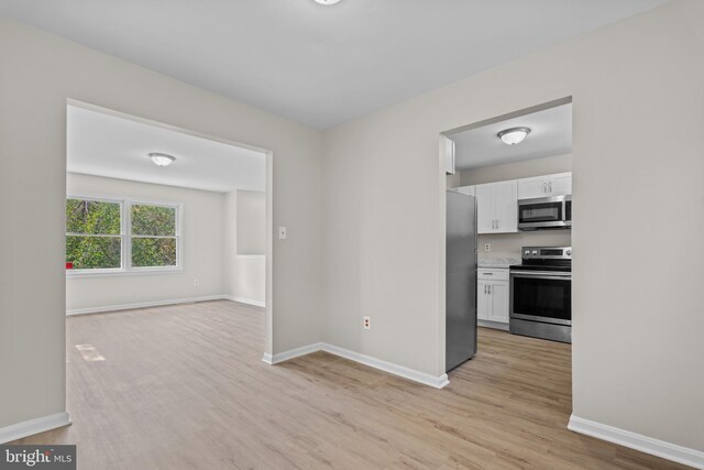 interior space featuring white cabinetry, light hardwood / wood-style flooring, and appliances with stainless steel finishes