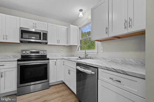 kitchen featuring sink, white cabinets, light hardwood / wood-style floors, and stainless steel appliances