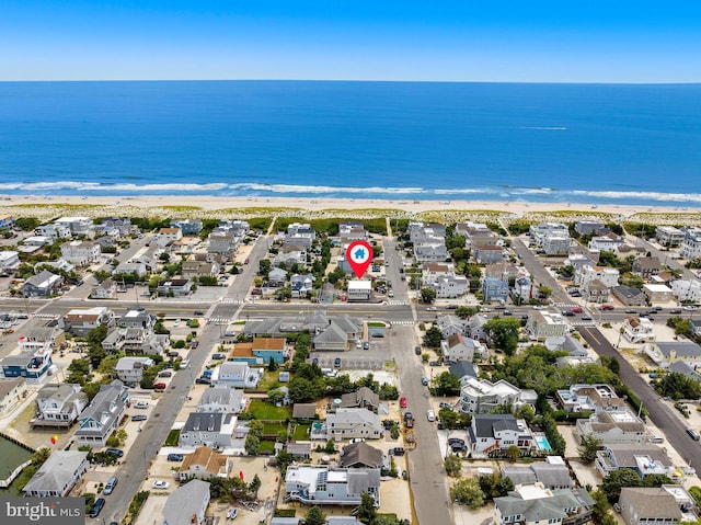 drone / aerial view with a beach view and a water view