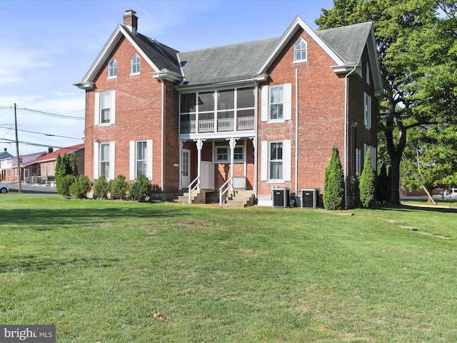 view of front property with cooling unit, a sunroom, and a front lawn