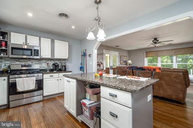 kitchen featuring white cabinetry, a center island, dark wood-type flooring, and range with gas stovetop