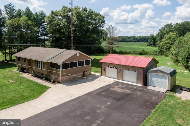 view of front of property featuring an outdoor structure, a garage, and a front yard