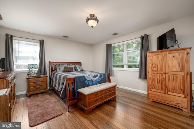 bedroom featuring visible vents, dark wood finished floors, and baseboards